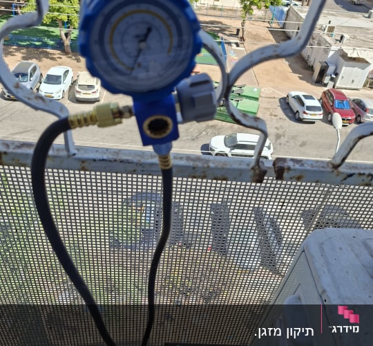 מד לחץ כחול מחובר למזגן על מרפסת